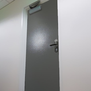 Дверь серебристого цвета с доводчиком 